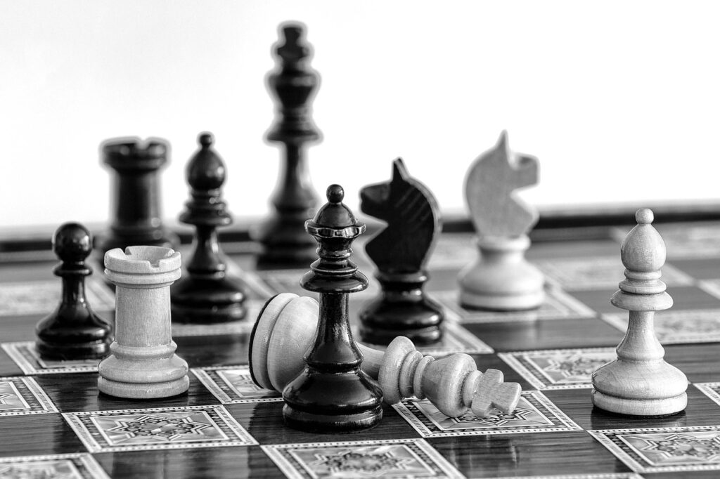 A black and white image of a chessboard captures the scene of intense negotiation, with knights, a king, and a rook strategically placed. Some pieces lie toppled over, reflecting the dramatic turns in this tactical showdown.