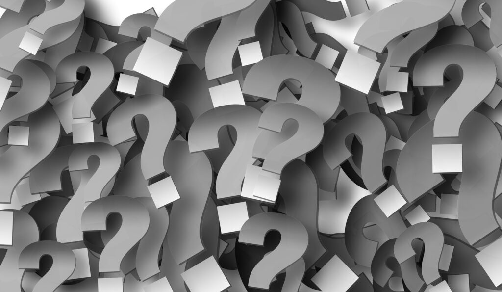 A large pile of overlapping, three-dimensional gray question marks fills the entire image, symbolizing confusion and uncertainty often associated with navigating the NHS.