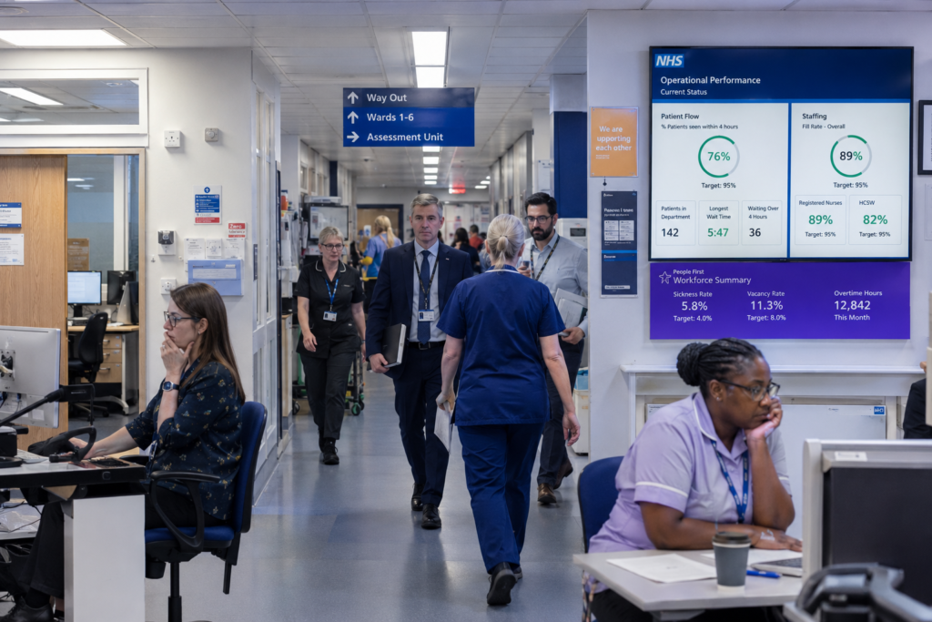 NHS staff working through organisational change and uncertainty in a busy hospital environment.